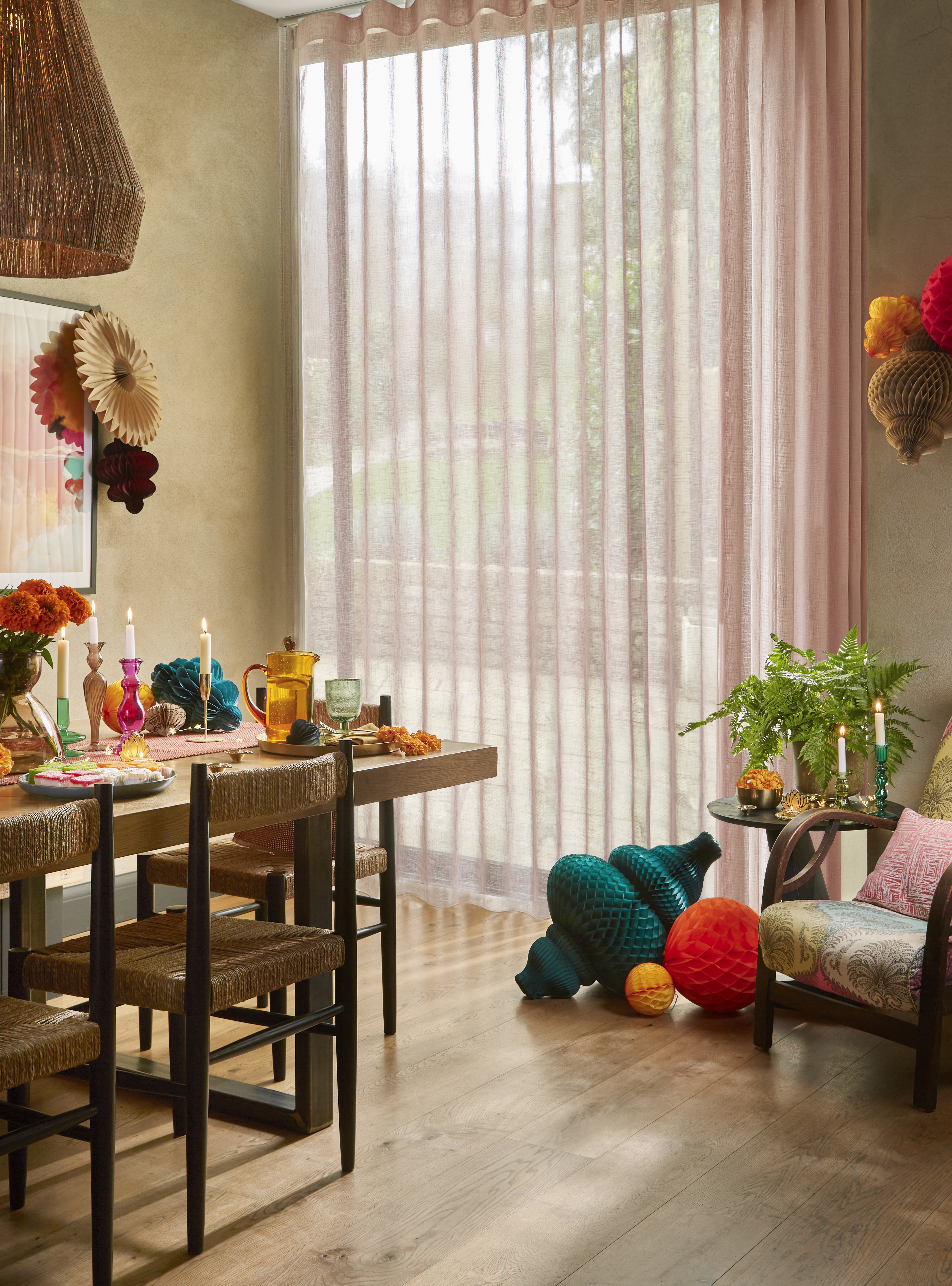 transparente gardiner i et fargerikt spiserom med lekne detaljer, levende lys og retroinspirert møblering